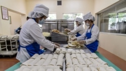 Employees produce wheat cakes stuffed with meat at the Kumsong Foodstuff Factory in Pyongyang on Sept. 24, 2021.