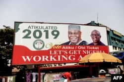 FILE - A billboard with a campaign poster bearing images of the opposition Peoples Democratic Party election candidate Atiku Abubakar and his running mate Peter Obi stands on a road in Abuja, Nigeria, Feb. 19, 2019.
