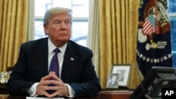 President Donald Trump prepares to sign Section 201actions in the Oval Office of the White House in Washington, Jan. 23, 2018. 