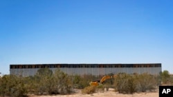 Government contractors erect a section of border wall along the Colorado River, Sept. 10, 2019 in Yuma, Ariz.