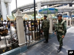 Thai soldiers walk outside the Erawan Shrine at Rajprasong intersection, the scene of last week's bombing, in Bangkok, Thailand, Aug. 24, 2015.