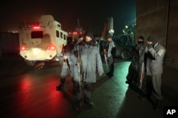 Afghan police soldiers stand guard at the site of a suicide attack near a compound belonging to foreigners in Kabul, Afghanistan, Jan. 4, 2016.