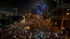 Tens of thousands of pro-democracy demonstrators, some waving lights from mobile phones, fill the streets in the main financial district of Hong Kong, Oct. 1, 2014.