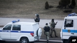 Police officers stand ready to prevent a rally commemorating the founding of Belarus' 1918 proclamation of independence from Russia, in Minsk, Belarus, Thursday, March 25, 2021.