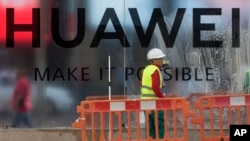 Workers clean the front of the new Huawei flagship store due to open soon in Madrid, Spain, May 22, 2019.