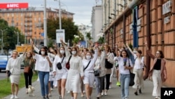 About 200 women march in solidarity with protesters injured in the latest rallies against the results of the country's presidential election in Minsk, Belarus, Aug. 12, 2020.