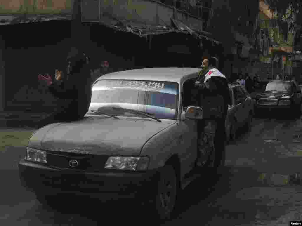 A Free Syrian Army fighter looks on as he holds the Syrian opposition flag during a protest against Syria's president and fighters from the Islamic State in Iraq and the Levant in Aleppo's Salaheddine neighborhood, Jan. 10, 2014.