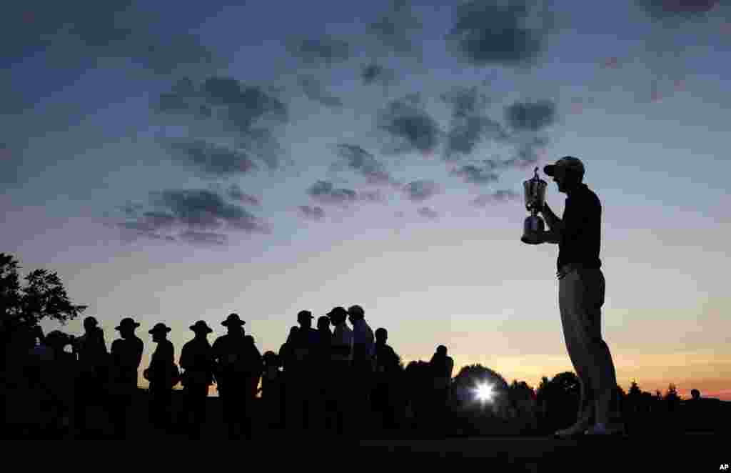 Dustin Johnson holds the trophy after winning the U.S. Open golf championship at Oakmont Country Club in Oakmont, Pennsylvania, June 19, 2016.