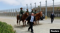 FILE - Former Immigration and Customs Enforcement (ICE) Deputy Director Thomas D. Homan walks to his vehicle after greeting U.S. border patrol agents on horseback during a visit to the U.S.-Mexico border wall near San Diego, California, May 7, 2018. 