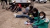 Menores no acompañadas que viajan solas desde Honduras, se sientan entre otros niños solicitantes de asilo mientras esperan ser transportados a una instalación de procesamiento de la patrulla fronteriza de EE. UU., el 6 de mayo de 2021.
