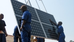 FILE -Workers are trained to install solar panels at a health clinic in Rwanda, Nov. 10, 2010.