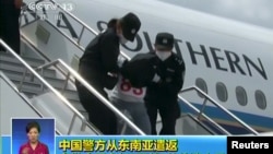 People being deported from Thailand are seen brought off an airplane by police at an unidentified location in China, July 9, 2015, in this still image taken from CCTV video aired on July 11, 2015. CCTV said they were mostly from the country's western Xinjiang region and were attempting to go to Turkey and then to join the Jihad in Syria and Iraq, and 13 of them were terror suspects. 