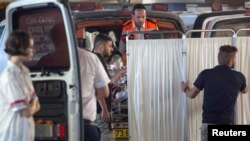 Medics take an Israeli woman who was injured during a knife attack in the West Bank settlement of Neve Tsuf into a hospital in Jerusalem, July 21, 2017.