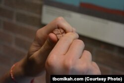 Mikah holds a piece of red pipestone.