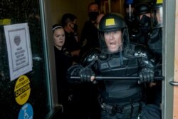 Police try to secure the public safety building from protesters, August 24, 2020, in Kenosha, Wisconsin.