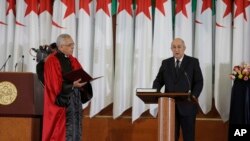 Algerian President Abdelmadjid Tebboune, right, is seen at his inauguration, at the presidential palace, in Algiers, Algeria, Dec. 19, 2019.