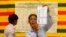 FILE - An election official shows a ballot paper as votes are counted at a polling station in Phnom Penh, July 28, 2013.