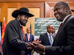 FILE - South Sudan's President Salva Kiir, left, and opposition leader Riek Machar, right, shake hands during peace talks in Addis Ababa, Ethiopia, June 21, 2018.