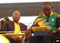 FILE - Newly-elected ruling African National Congress (ANC) party president, Cyril Ramaphosa, right, and former ANC president and South African President Jacob Zuma, left, attend the party's 106th birthday celebrations in East London, South Africa, Jan. 13, 2018.