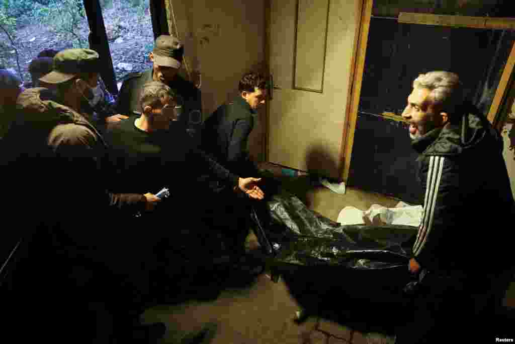 Men carry a body, believed to be of a prisoner from Sednaya prison, according to forensic official Zaher al-Taqesh, at the Al Mojtahed hospital in Damascus, Dec. 10, 2024.