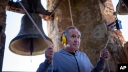 Xavier Masó, a student of the Vall d'en Bas School of Bell Ringers, performs playing two bronze bells at the church bell tower of the12th-century Sant Romà church, at the tiny village of Joanetes, about two hours north of Barcelona, Spain, June 29, 2024.