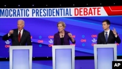 Democratic presidential candidate former Vice President Joe Biden, left, Sen. Elizabeth Warren, D-Mass., center and South Bend Mayor Pete Buttigieg speak during a Democratic presidential primary debate at Otterbein University, Tuesday, Oct. 15, 2019.