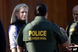 FILE - U.S. Department of Homeland Security Secretary Kirstjen Nielsen (L) speaks with Border Patrol agents near a newly fortified border wall structure, Oct. 26, 2018, in Calexico, Calif.