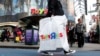 FILE - Shoppers pass by the Toys R Us store at Times Square in New York.