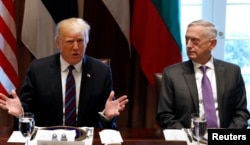 FILE - With U.S. Secretary of Defense James Mattis at his side, U.S. President Donald Trump speaks during a meeting at the White House in Washington, April 3, 2018.