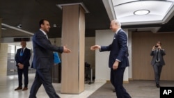 نصر الحریر نمایندۀ شورشیان سوری حین دست دادن با ستیفن دی میستورا نمایندۀ ویزۀ ملل متحد در امور سوریه