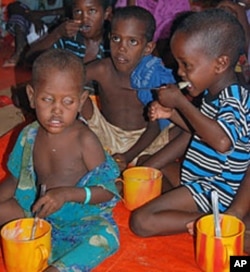 Newly arrived Somali refugee children receive their first hot meal of cereal at a feeding center run by Save the Children USA at the Dollo Ado refugee reception station, Ethiopia, October 26, 2011