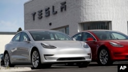 FILE - New 2018 Model 3 vehicles are seen on a Tesla dealer's lot in Littleton, Colorado, April 15, 2018.