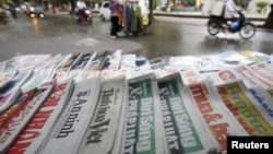 FILE - State-run newspapers are displayed for sale on a street in Hanoi, Vietnam, Sept. 26, 2015. The New York Times announced it will open a bureau in Vietnam, where it has not had a presence since 1975. 
