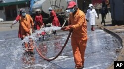 Des employés du conseil municipal de la capitale désinfectent un terminal de bus, à Harare, Zimbabwe, le 1er avril 2020.