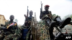 FILE - Child soldiers of the Seleka coalition sits on a pickup truck near the Presidential palace in Bangui, March 25, 2013. 