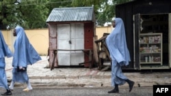 FILE - Girls walk home after school in Maiduguri on July 5, 2017. 