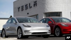 FILE - New 2018 Model 3 vehicles are seen on a Tesla dealer's lot in Littleton, Colorado, April 15, 2018.