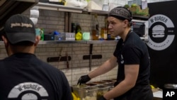 The workers of White Burger restaurant prepare an order in Kramatorsk, Ukraine, Wednesday, Sept. 13, 2023. A Gallup poll released Oct. 26, 2023, said most Ukrainians are optimistic about the future.
