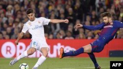 Marco Asensio rivalise avec Gerard Pique, lors du match entre le FC Barcelone et le Real Madrid CF, en Espagne, le 6 mai 2018.
