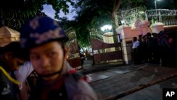 A security officer closes the gate at Myanmar's Bishop's house after a convoy of vehicles carrying Myanmar's military leader, Gen. Min Aung Hlaing, enters for a meeting with Pope Francis, Nov. 27, 2017, in Yangon, Myanmar.