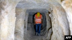 A municipal employee walks inside the Matiate archaeological site underneath the town in Midyat in Mardin province, southeastern Turkey, on July 1, 2024.