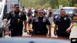 FILE - Police walk near Robb Elementary School following shootings on May 24, 2022, in Uvalde, Texas. A federal report released on Jan. 18, 2024, into the halting law enforcement response to the shootings revived scrutiny of the hundreds of officers who responded to the massacre.