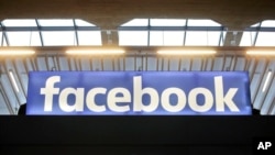 FILE - The Facebook logo is displayed at a gathering for startup companies at Paris' Station F., Jan. 17, 2017.
