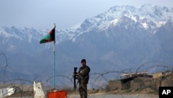 FILE - An Afghan National Army soldier stands guard at a checkpoint near the Bagram base north of Kabul, Afghanistan, April 8, 2020.