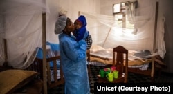 Seorang asisten perawat sedang merawat bayi di Pusat Perawatan Ebola di Butembo, 13 Agustus 2019. (Unicef)