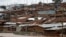 FILE - A man watches a stream from his home in Nairobi's Kibera slum, Kenya, Dec. 3, 2019. 