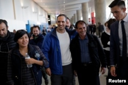 Zabihollah Zarepisheh of Iran (2nd R) smiles after being released from being held in Terminal 4 for over 30 hours as part of President Donald Trump's travel ban at John F. Kennedy International Airport in Queens, New York, Jan. 29, 2017.