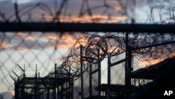 FILE - Dawn arrives at the now-closed Camp X-Ray, which was used as the first detention facility for al-Qaida and Taliban militants who were captured after the Sept. 11 attacks, at the Guantanamo Bay Naval Base, Cuba. 