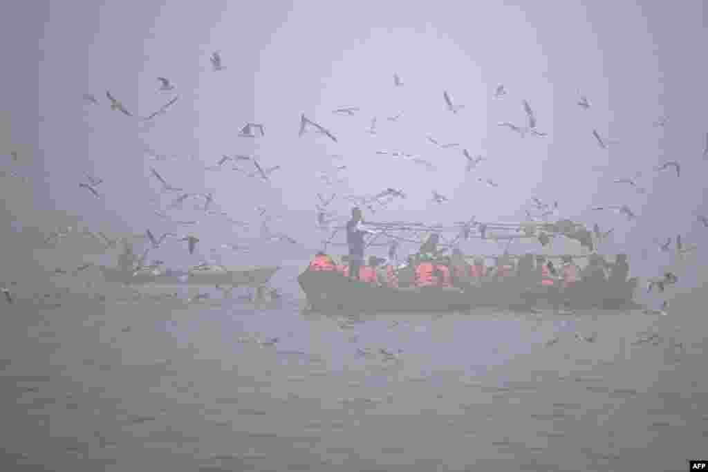 Rescue personnel ferry a boat for security measures, at Sangam, the confluence of Ganges, Yamuna and mythical Saraswati rivers, during the Maha Kumbh Mela festival in Prayagraj on Jan. 13, 2025.
