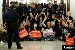 Demonstrators chant before being arrested as they protest against U.S. Supreme Court nominee Brett Kavanaugh in front of the office of Senator Susan Collins (R-ME) on Capitol Hill in Washington, Sept. 24, 2018.